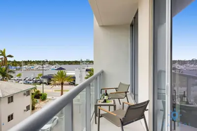 a balcony with chairs and a table and a view of a parking lot at Exclusive Apartment - Rooftop Pool - Hollywood Beach in Hollywood