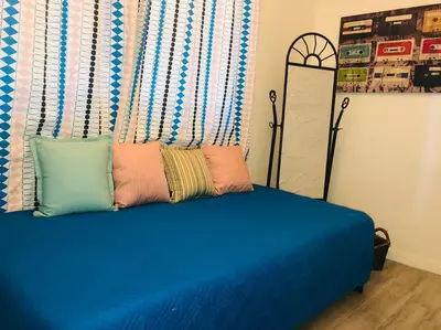 a blue bed with pillows on top of it at Private and Comfy Cabin near to MIA airport in Miami