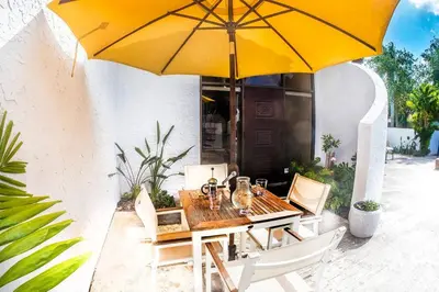 a wooden table with a yellow umbrella on a patio at Villa at St. James Place “H”, Luxury, Pet Friendly in Miami