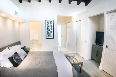a bedroom with a large bed and a television at Villa at St. James Place “H”, Luxury, Pet Friendly in Miami