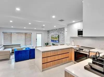 a kitchen and living room with a stove and a couch at 5-star Lakefront Oasis In Hollywood-Hard rock casino in Fort Lauderdale