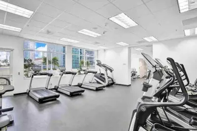 a gym with rows of treadmills and cardio machines at 40th floor Ocean View - Best Location in Miami