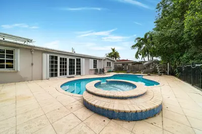 a swimming pool in front of a house at Pool House on the Water 2 in Miami