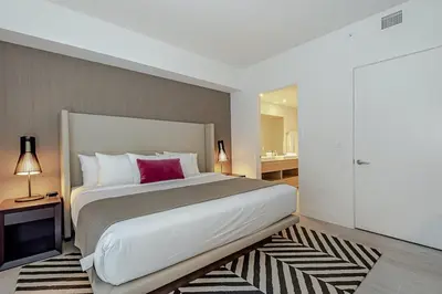 a bedroom with a large bed with a red pillow at Wrap Around Balcony - 2Br - Amazing Views - Pools in Hollywood