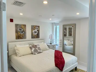 a white bedroom with a bed and a mirror at Direct Ocean View - Luxurious condo in South Beach in Miami Beach