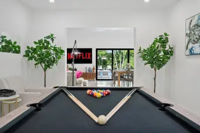 a pool table in a living room with a billiard at VillaLee-Jungle Palm Island white marble pool Area in Miami