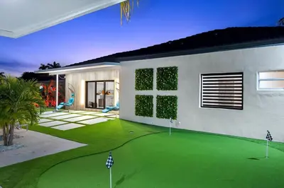 a house with a green lawn in front of it at VillaLee-Jungle Palm Island white marble pool Area in Miami