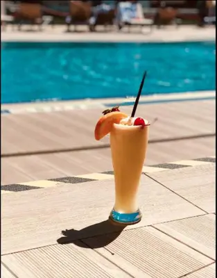 a drink sitting on a table next to a pool at Relaxing BeachWalk Getaway Studio for 4 Guests 405B in Hallandale Beach