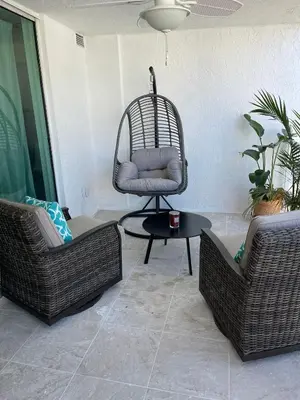 a living room with two wicker chairs and a chairitures at Lujoso apartamento en Brickell in Miami
