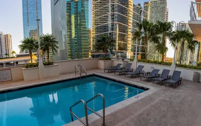 a swimming pool on the roof of a building with tall buildings at Lujoso apartamento en Brickell in Miami