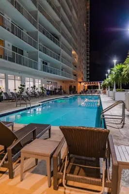 a swimming pool at night with chairs and a hotel at Lujoso apartamento en Brickell in Miami