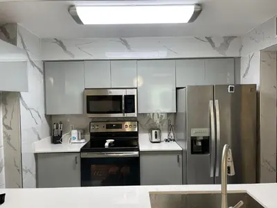 a kitchen with white cabinets and stainless steel appliances at Lujoso apartamento en Brickell in Miami