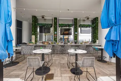 a restaurant with tables and chairs in front of a bar at Ocean Front State Of The Art in Hollywood