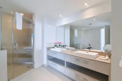 a bathroom with two sinks and a large mirror at Zen Direct Ocean Front Deluxe 3-Bedroom in Hollywood