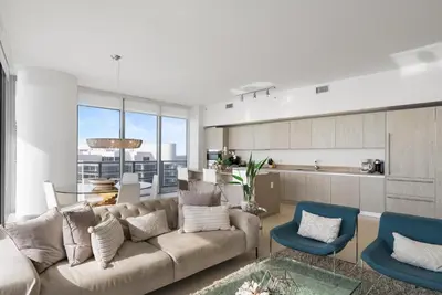 a living room with a couch and blue chairs at Zen Luxury Resort Ocean Front Penthouse in Hollywood
