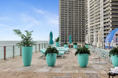 a balcony with chairs and umbrellas on the beach at Zen Luxury Resort Ocean Front Penthouse in Hollywood