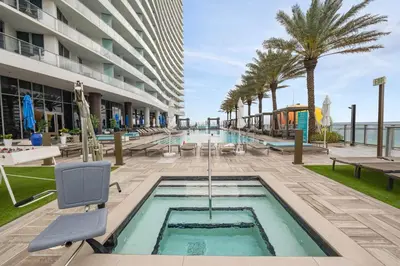 a pool at a hotel with palm trees and a building at Zen Luxury Resort Ocean Front Penthouse in Hollywood