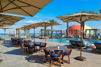 a resort with a pool and tables and umbrellas at Zen Vacation Rentals Direct Ocean Front Low Floor in Hollywood