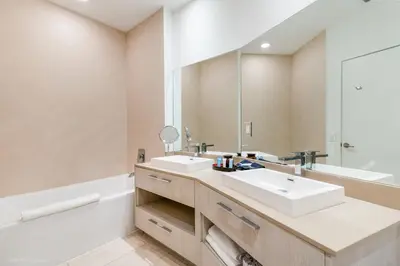 a bathroom with two sinks and a large mirror at Zen Vacation Rentals Direct Ocean Front Low Floor in Hollywood