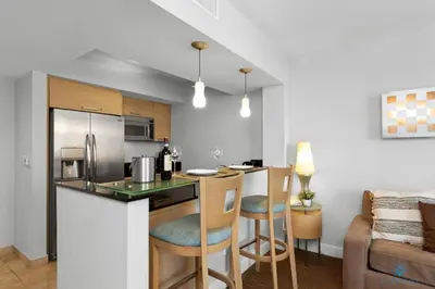 a kitchen and living room with a bar and a couch at Beachfront Resort POOL OCEAN VIEW BALCONY in Miami Beach