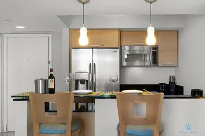 a kitchen with a table with chairs and a refrigerator at Beachfront Resort POOL OCEAN VIEW BALCONY in Miami Beach