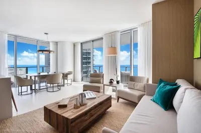 a living room with a white couch and a table at Zen Vacation Rentals Ocean Front at Lyfe Resort in Hollywood