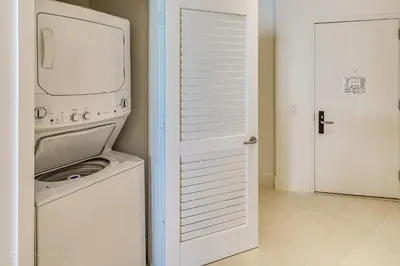 a washer and dryer in a white laundry room at Zen Vacation Rentals Ocean Front at Lyfe Resort in Hollywood