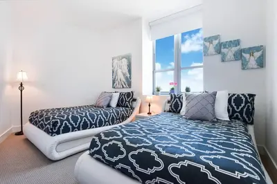 a bedroom with two beds and a window at Million Dollar Ocean Front Penthouse by Zen Vacation Rentals in Hollywood