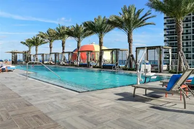 a pool on the roof of a building with palm trees at Million Dollar Ocean Front Penthouse by Zen Vacation Rentals in Hollywood