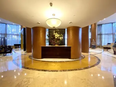 a lobby with a large lobby with columns and a table at Trump International Resort by Zen Vacation Rentals in Miami Beach