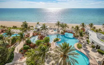 an aerial view of a resort with a swimming pool and the beach at Trump International Resort by Zen Vacation Rentals in Miami Beach