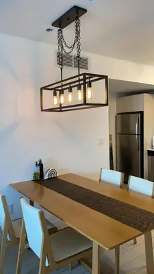 a dining room table with chairs and a chandelier at Designer Beachfront Apartment Views, Luxury & Full Kitchen 805 A in Hallandale Beach