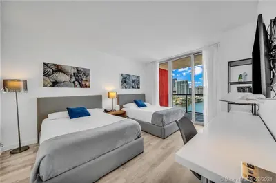 a hotel room with two beds and a table and a desk at Charming Room by the Beach Pure Relaxation 2004 B in Hallandale Beach
