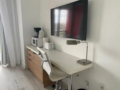 a white desk with a television on a wall at Charming Room by the Beach Pure Relaxation 2004 B in Hallandale Beach
