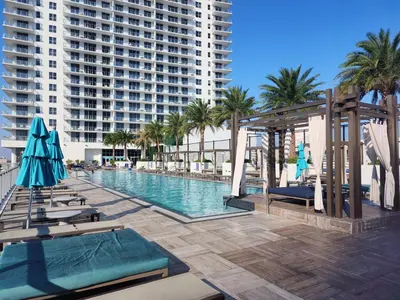 a swimming pool with chairs and umbrellas and a building at Modern Waterfront Retreat with Scenic Views in Hollywood