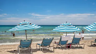 a group of chairs and umbrellas on a beach at Modern Waterfront Retreat with Scenic Views in Hollywood