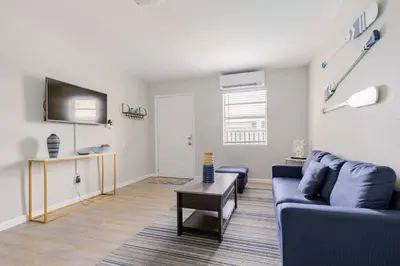 a living room with a blue couch and a table at Luxury House with Delightful Beach Style! in Dania Beach