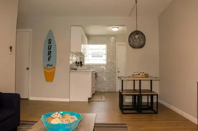 a living room with a surfboard on the wall at Luxury House with Delightful Beach Style! in Dania Beach
