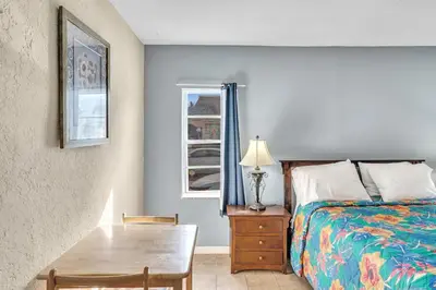 a bedroom with a bed and a table and a window at Charter House in Hollywood