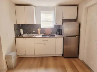 a kitchen with white cabinets and a stainless steel refrigerator at Lovely Apartment Near Brickell 3 in Miami