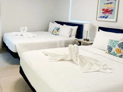 two beds in a room with white sheets at Top Stay Miami Green Brickell in Miami