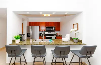 a kitchen with a counter and four stools at Top Stay Miami Green Brickell in Miami