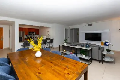 a living room with a wooden table and blue chairs at Top Stay Miami Green Brickell in Miami