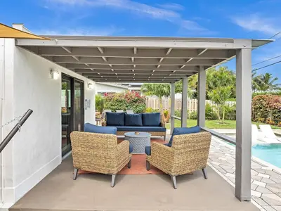 a patio with a couch and chairs and a table at Walk 2 Wilton! Heatd Pool & 10 min to Bch Las Olas in Fort Lauderdale