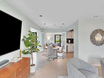 a living room with a tv and a table with chairs at Walk 2 Wilton! Heatd Pool & 10 min to Bch Las Olas in Fort Lauderdale
