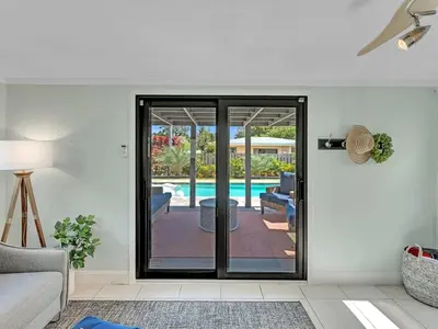 a living room with a door leading to a pool at Walk 2 Wilton! Heatd Pool & 10 min to Bch Las Olas in Fort Lauderdale