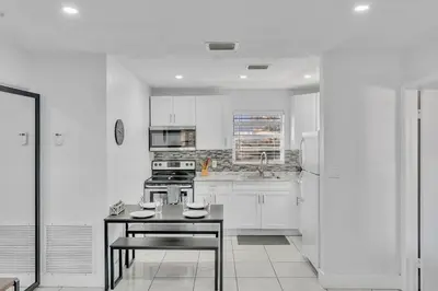 a kitchen with white cabinets and a table in it at Hollywood Vacation In Perfect Beach Location Ha01 in Hollywood