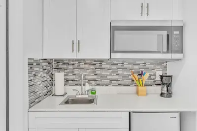 a white kitchen with a sink and a microwave at Large 2 Bed Studio Close to Beach & Hard Rock HA03 in Hollywood