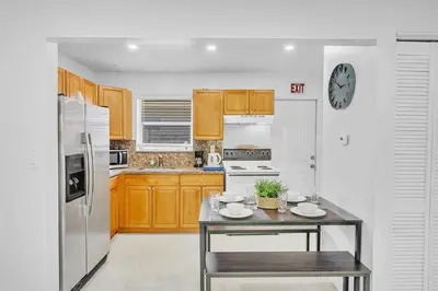 a kitchen with wooden cabinets and a white refrigerator at NEW 2 Bedroom Hollywood Beach and Hard Rock LB1 in Hollywood