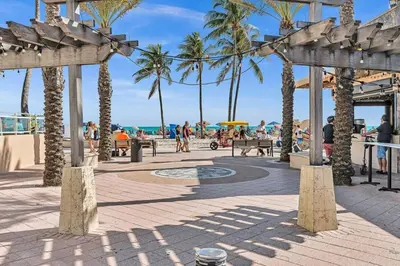 a beach with palm trees and people walking on the beach at NEW 2 Bedroom Hollywood Beach and Hard Rock LB1 in Hollywood